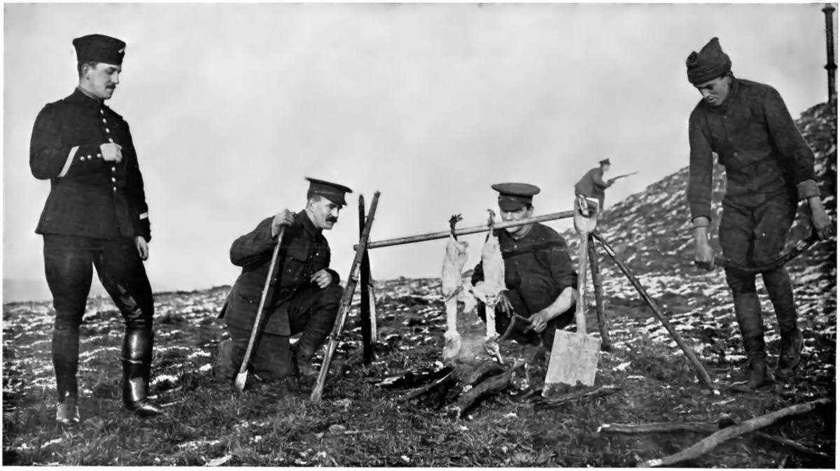 WITH "SPIT" HELD BY RIFLES, A SPADE, AND A COUPLE OF STICKS: COOKING THE CHRISTMAS GEESE AT THE FRONT.